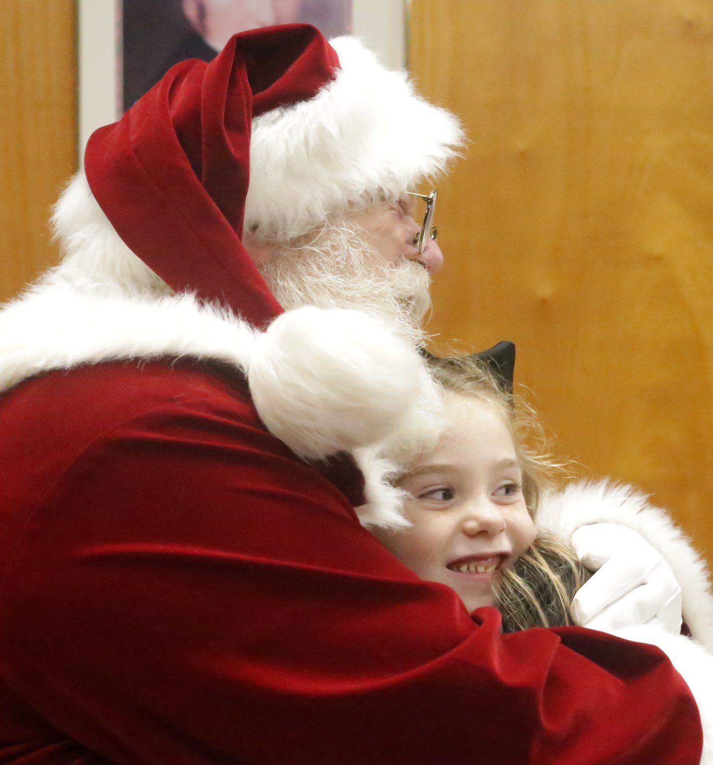 One of Santa’s visitors at the Mineola library got a hug from the Christmas icon after sharing her wishes.